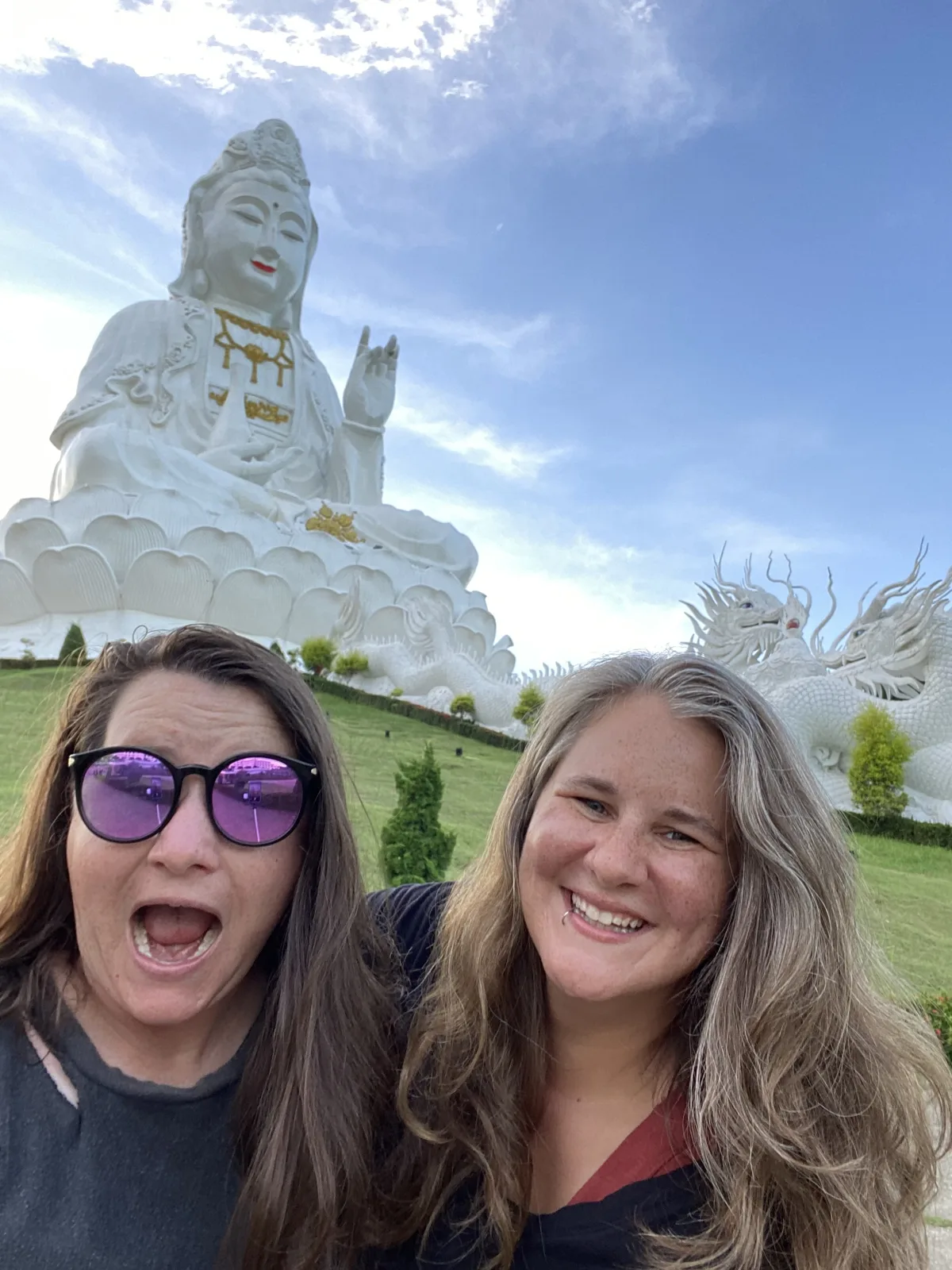 Mariya and Sam smiling in front of a giant white statue